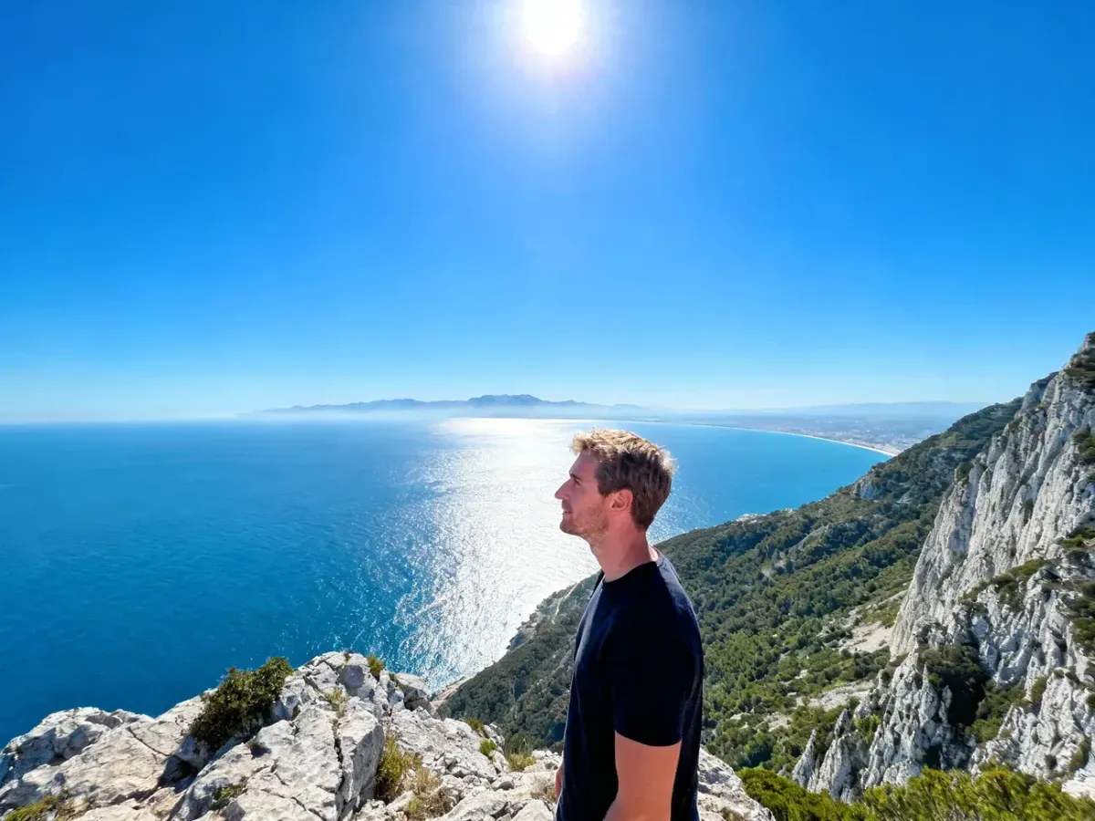 Mężczyzna podziwiający panoramę Cieśniny Gibraltarskiej z widocznym w oddali wybrzeżem Afryki.